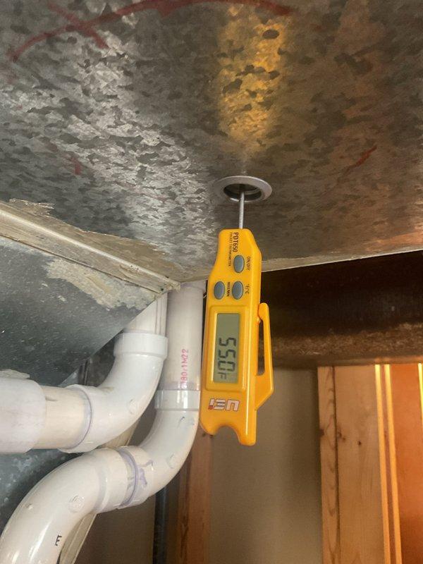 Performed routine HVAC cooling maintenance on residential air conditioning system. Inspected outdoor condenser unit with protective metal guard, confirmed proper mounting and drainage on gravel pad, and verified all components in good working condition. Measured supply air temperature at 55°F at indoor air handler located in attic space, confirming system operating within normal parameters.
