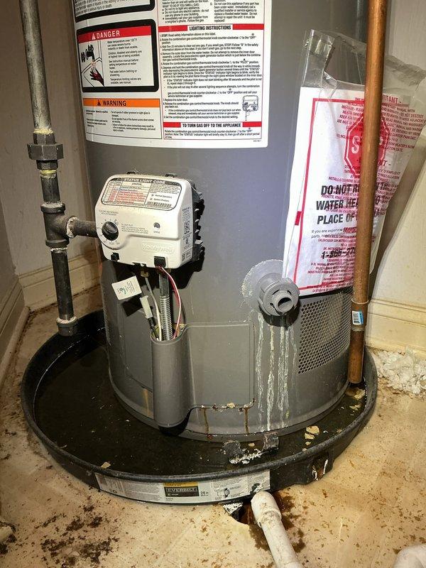 Responded to service call for excessive indoor humidity levels above 60% causing moisture damage to wooden flooring. Upon arrival, conducted thorough inspection of HVAC system and related equipment. Investigation revealed the issue was related to the water heater installation rather than the air conditioning system. Inspected Rheem Performance water heater and associated plumbing connections, including expansion tank, copper piping, and drain pan assembly. Documented equipment condition and installation setup with photographic evidence. Verified all safety labels and warning documentation were properly posted. Assessed concrete floor for water staining and examined drain pan for proper function to identify potential condensation sources affecting indoor humidity levels.