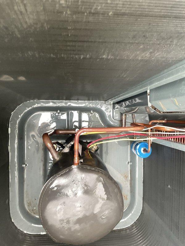 Responded to callback regarding unsatisfactory cleaning of air conditioning unit. Upon arrival, found significant accumulation of debris, leaves, and sediment in drain pan as reported. Performed thorough cleaning of drain pan and surrounding areas, removing all organic matter and buildup. Inspected system components including evaporator coil, refrigerant lines, and accumulator. Noted heavy frost buildup on accumulator indicating proper refrigerant cycle operation. Verified copper line connections secure and heat exchanger fins intact. Cleared all debris from base pan and ensured proper drainage. System left clean and operational with customer satisfaction confirmed.
