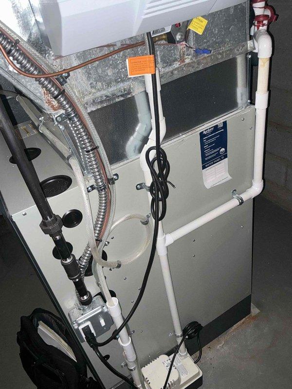Completed HVAC system estimate for equipment replacement in residential utility space with easy access conditions. Evaluated existing furnace unit with associated ductwork, refrigerant lines, condensate drainage system including P-trap configuration, and electrical connections. Documented current system components including air handler plenum, flexible ductwork, copper refrigerant piping, and PVC condensate drain assembly to provide comprehensive replacement options for aging equipment showing signs of wear.