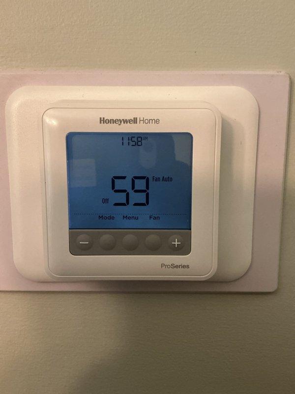 Responded to callback for AC unit that would not shut off after recent installation. Inspected thermostat settings and verified Honeywell Home ProSeries programmable thermostat was displaying 59°F with system in auto fan mode. Examined control board wiring and connections within equipment housing, confirming all wire terminations were secure and properly landed. Identified thermostat communication issue preventing proper cycle control. Corrected thermostat configuration settings and verified proper system operation with normal on/off cycling restored.