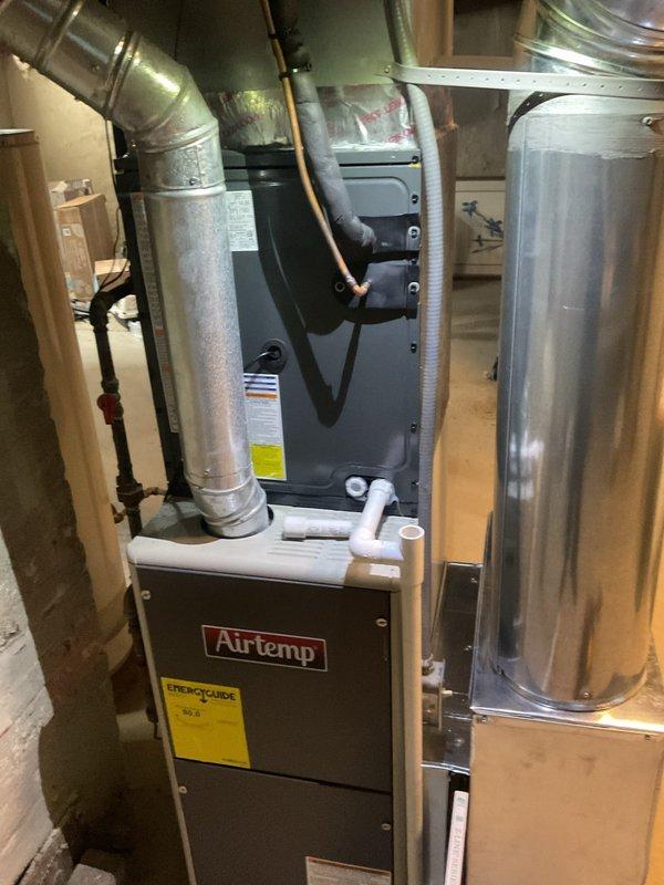 Completed contract cooling tune-up on residential Airtemp furnace system. During inspection, discovered severe frost accumulation on supply ductwork in attic space, with surface temperature measuring 51.6°F, indicating significant airflow restriction or refrigerant issue affecting cooling performance. Documented equipment condition and duct frost buildup for further diagnostic evaluation and necessary repairs to restore proper system operation.