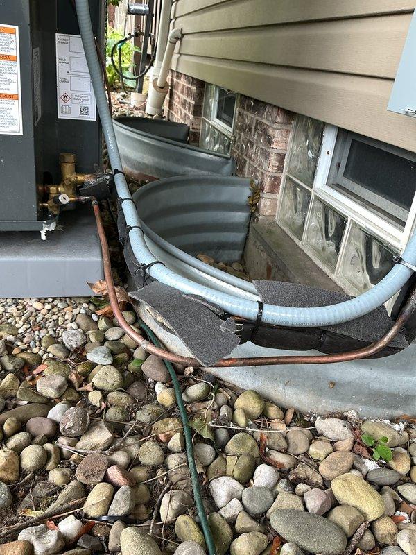 Responded to no cooling call on 3-month-old system displaying sensor error code at thermostat. Upon arrival, inspected outdoor condensing unit and refrigerant line installation along foundation. Documented equipment condition and piping configuration for diagnostic purposes, identifying potential sensor communication issue requiring further troubleshooting to restore system operation.