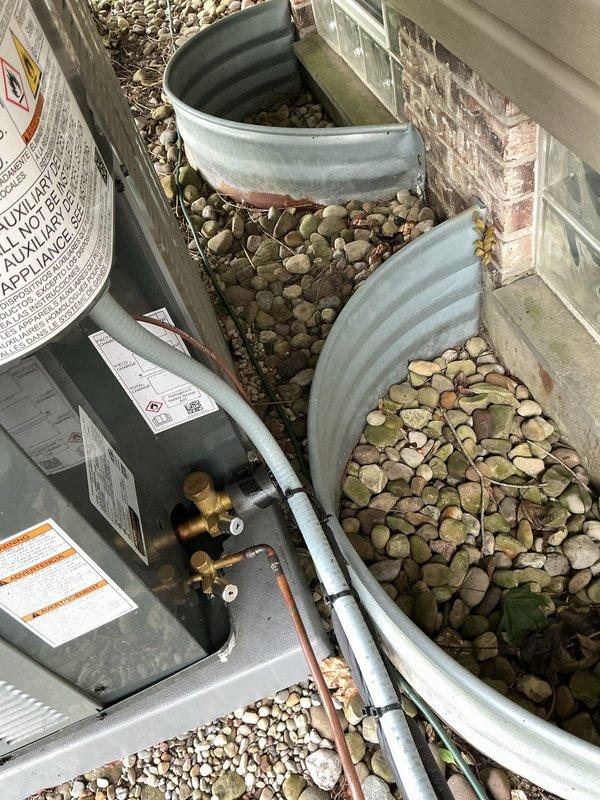 Responded to no cooling call on 3-month-old system displaying sensor error code at thermostat. Upon arrival, inspected outdoor condensing unit and refrigerant line installation along foundation. Documented equipment condition and piping configuration for diagnostic purposes, identifying potential sensor communication issue requiring further troubleshooting to restore system operation.