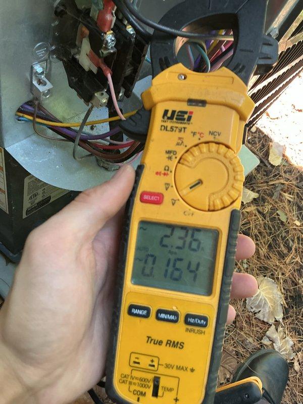 Completed cooling system tune-up on outdoor HVAC unit. Performed electrical diagnostics using digital multimeter to verify voltage and amperage readings at capacitor and compressor connections. System tested and operating within normal parameters.