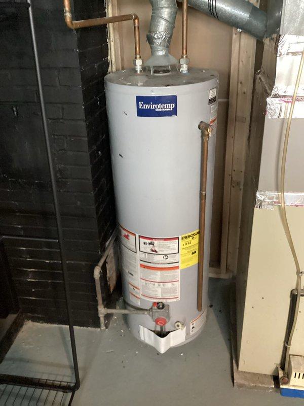 Responded to service call for Envirotemp tanked water heater experiencing internal tank leak causing pilot flame extinguishment. Upon inspection, confirmed water leakage from inside the tank contaminating the burner assembly and preventing proper ignition. Unit determined to be beyond economical repair due to compromised tank integrity requiring full replacement.