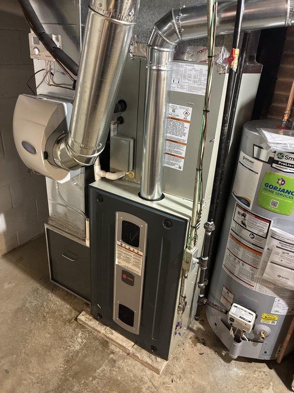 Completed full HVAC system installation including 80% efficiency furnace, air conditioning unit, and ductwork with liner in residential basement location. Installed new furnace unit with proper electrical circuit connection, verified all wiring connections and control board functionality using digital multimeter for voltage and amperage readings. Connected metallic ductwork with secure fastening and proper sealing, ensuring optimal airflow throughout the system. Integrated wall-mounted humidifier unit to furnace system for whole-home humidity control. Verified all manufacturer specifications, safety controls, and operational parameters met code requirements. System tested and confirmed operational with all components functioning as designed.