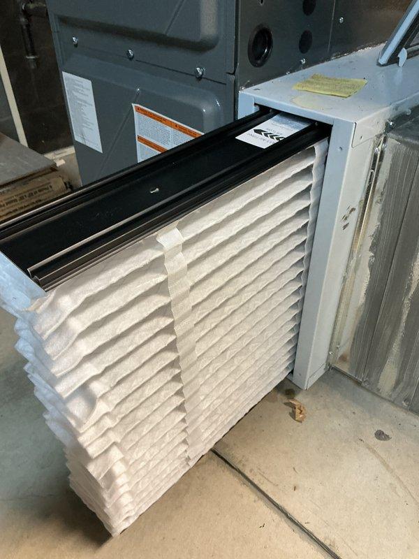 Completed scheduled cooling system maintenance on residential HVAC unit. Inspected furnace cabinet, verified proper venting through PVC intake and exhaust pipes, examined pleated air filter for cleanliness and airflow efficiency, and documented equipment condition with warning labels intact and visible. All components operating within normal parameters with no issues identified during this preventive maintenance visit.
