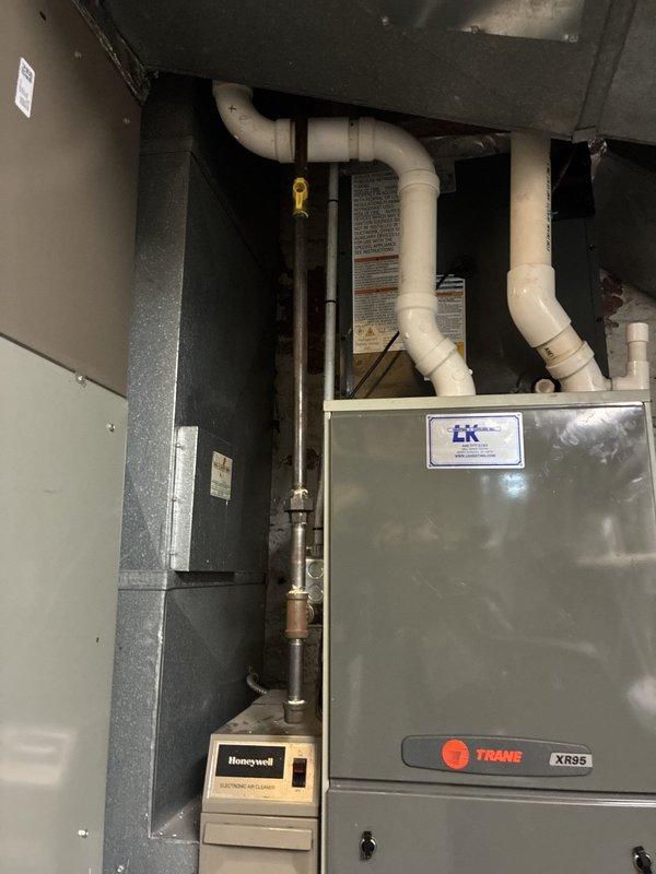 Completed installation of new air conditioning system integrated with existing Trane XR95 furnace. Installed and configured outdoor condensing unit, refrigerant lines, and electrical connections. Verified system operation with digital multimeter readings showing proper voltage at 66.4V, confirming electrical components functioning within manufacturer specifications. Routed and secured all necessary condensate drain lines and refrigerant piping, ensuring proper airflow through existing ductwork and plenum assembly.