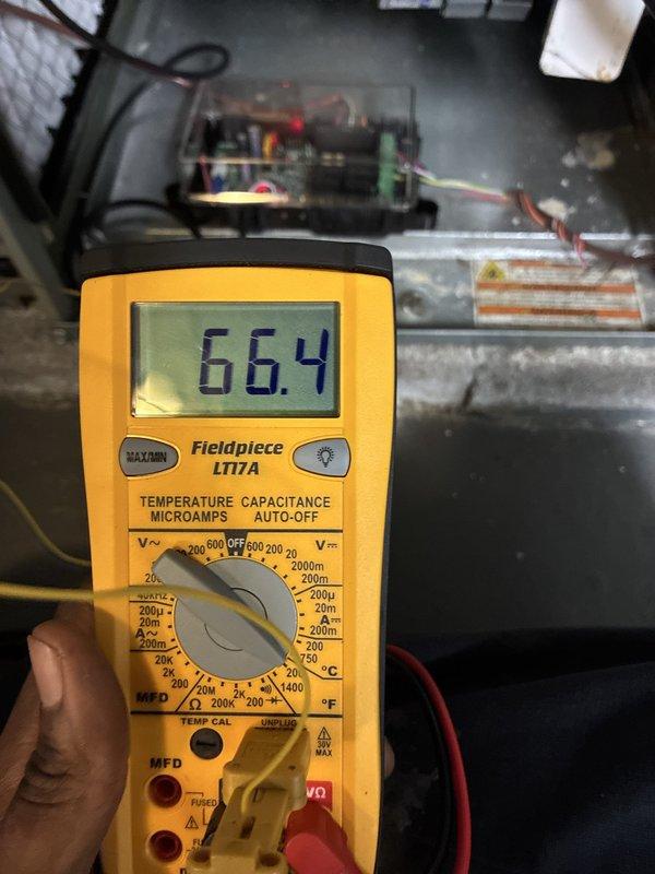 Completed installation of new air conditioning system integrated with existing Trane XR95 furnace. Installed and configured outdoor condensing unit, refrigerant lines, and electrical connections. Verified system operation with digital multimeter readings showing proper voltage at 66.4V, confirming electrical components functioning within manufacturer specifications. Routed and secured all necessary condensate drain lines and refrigerant piping, ensuring proper airflow through existing ductwork and plenum assembly.