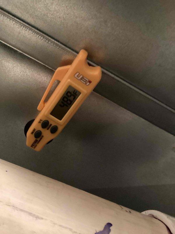 Completed routine cooling maintenance on outdoor HVAC unit, including refrigerant line inspection and electrical diagnostics using digital multimeter on ductwork connections. All system components tested and found operating within normal parameters, with tools staged for refrigerant pressure checks and connection service.