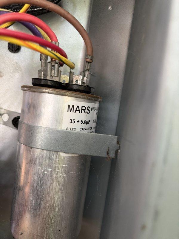 Completed scheduled cooling system maintenance on residential HVAC unit. Inspected and verified proper operation of dual-run capacitor (35+5 MFD), confirmed all electrical connections secure at terminal block. Measured supply air temperature at floor register reading 53.8°F, indicating adequate cooling performance and proper refrigerant charge. Assisted customer with locating main water shut-off valve, identified in laundry room area as requested.