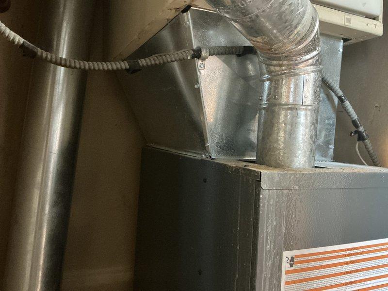 Completed air conditioning system evaluation and provided replacement options for existing equipment. The existing furnace, which was replaced a few years ago, remains in good operational condition with properly installed ductwork and plenum connections. The outdoor condensing unit shows signs of age and vegetation encroachment requiring clearance for optimal airflow and efficiency.