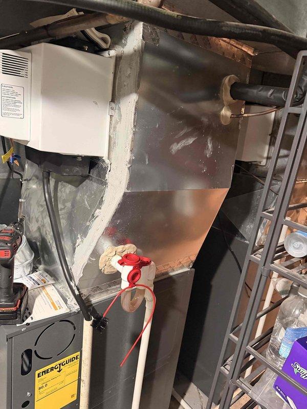 Completed warranty inspection on HVAC installation identifying two issues requiring correction. Installed missing tamper caps on outdoor unit furthest from street and properly sealed plenum on unit near basement stairs where side panel had separated creating a one-inch gap. All deficiencies documented with photos and corrected to manufacturer specifications.