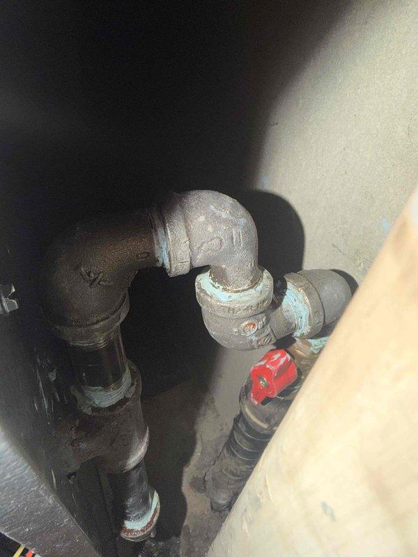 Completed HVAC installation warranty inspection and corrective work. Installed new drip leg on gas line and replaced gas shut-off valve with new ball valve for improved system safety and code compliance. Verified gas cock operation and conducted comprehensive quality check on entire system installation, confirming proper equipment placement in confined space between interior and exterior walls, secure pipe connections, and adequate clearances for service access.