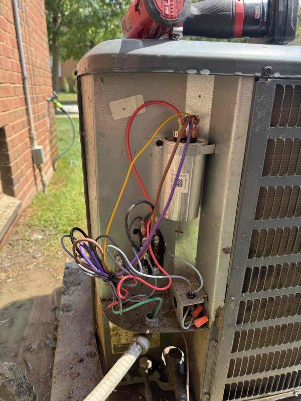 Responded to service call for air conditioning system not cooling properly with thermostat temperature reading spontaneously rising into the 80s without adjustment. Performed diagnostic inspection of outdoor condensing unit, removed access panels to examine electrical components, wiring connections, and capacitor. Tested system operation and verified proper electrical connections at compressor and control board to identify source of temperature control malfunction requiring manual thermostat resets.