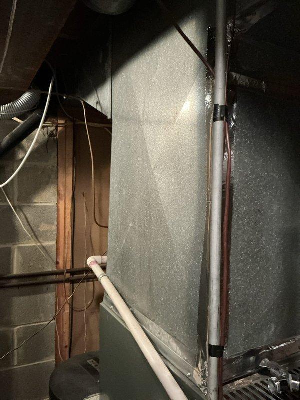 Conducted on-site evaluation of non-functional residential air conditioning system in basement utility area. Inspected existing HVAC equipment, ductwork, refrigerant lines, and electrical connections to assess system condition and replacement requirements. Documented equipment configuration including furnace panel, copper refrigerant lines with insulation, vertical conduit, and galvanized metal ductwork. Evaluated installation space, structural considerations, and utility access points to determine optimal replacement system specifications and installation approach for complete cooling system replacement estimate.