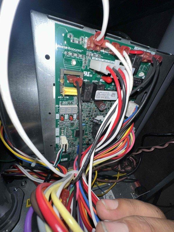Completed scheduled cooling system maintenance on HVAC unit. Inspected and photographed White Rodgers control board and wiring connections, verifying all electrical connections were secure. Examined dual run capacitor and associated wiring terminals, confirming proper operation. Noted outdoor equipment location with environmental exposure including vegetation growth near unit base. All components tested and found operational at time of service.