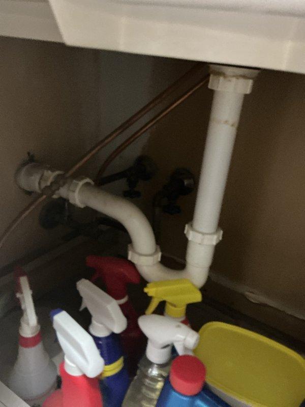 Completed comprehensive whole home plumbing inspection during afternoon visit. Documented bathroom plumbing conditions including vanity sink with chrome two-handle faucet assembly, drain components, and under-sink cabinet configuration with standard P-trap, PVC drainage piping, and copper supply lines. All accessible plumbing fixtures and connections were visually inspected and photographed for record purposes.
