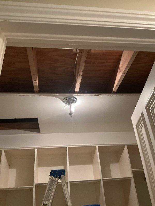 Responded to report of water leak originating from attic-mounted air conditioning unit causing ceiling damage. Upon inspection, identified condensate drainage issue at PVC drain line connection point with improper pitch or blockage causing water overflow. Condensate leak had saturated ceiling material, requiring removal of damaged drywall section to expose structural joists and allow proper drying. Cleared condensate drain line obstruction, verified proper drainage flow, and secured drain line connections with appropriate clamps. Confirmed unit is now draining properly with no active leaks present.