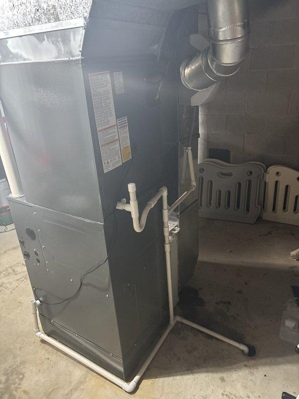 Completed installation of new residential air conditioning system including outdoor condenser unit and associated components. Unit was properly positioned on protective pad with gravel base for drainage, mounted against exterior wall with appropriate clearances, and connected to existing indoor furnace system via refrigerant lines and electrical conduit. All refrigerant connections were secured, system was pressure tested, evacuated, and charged to manufacturer specifications. Verified proper operation of condenser fan, compressor cycling, and airflow through existing ductwork.