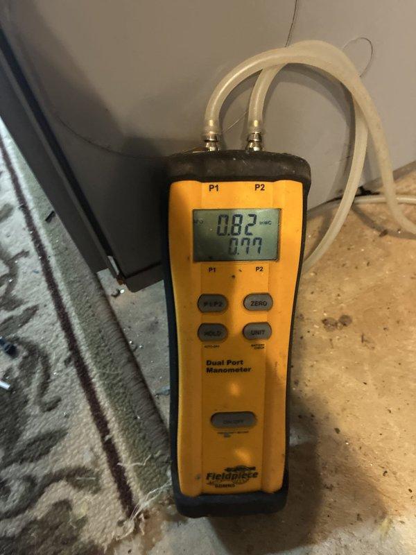 Completed installation of two air conditioning systems with two air scrubber units. Performed diagnostic testing and verification measurements using digital manometer to confirm proper pressure differentials and airflow, with readings indicating system operating within manufacturer specifications at 0.82 inWC. Temperature verification conducted showing ambient conditions at 69.9°F during commissioning phase.