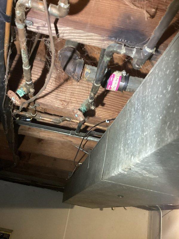 Responded to a leak between the toilet supply line and main plumbing stack. Inspected vertical drain pipe in basement utility area and overhead plumbing connections in crawl space, identifying compromised joint connections causing water seepage. Repaired leaking pipe fittings and secured all connections to restore proper function and prevent further water damage.