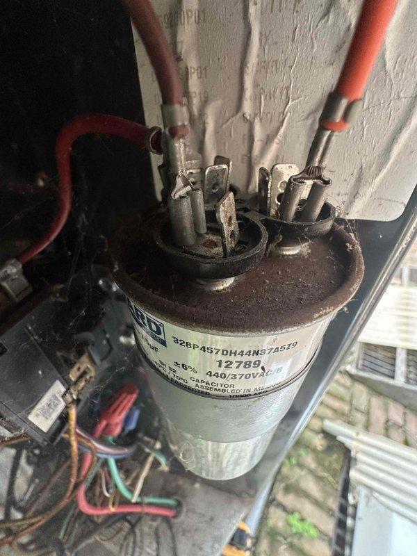 Completed scheduled preventive maintenance on residential cooling system. Inspected and replaced two heavily corroded TR40R 40-amp 250V AC fuses in the outdoor condensing unit. Identified failed dual-run capacitor (440/370VAC) exhibiting severe rust and corrosion on terminal assembly and replaced with new component to restore proper compressor and condenser fan motor operation.