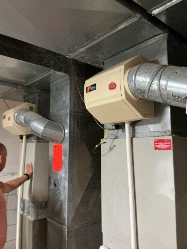 Responded to customer complaint of air conditioning system running but not cooling, with indoor temperature reading 78°F despite thermostat set to 69°F. Inspected dual Trane HVAC unit installation in mechanical room, examining equipment operation, ductwork connections, and system components. Documented system configuration and current operating conditions with tagged equipment for reference.