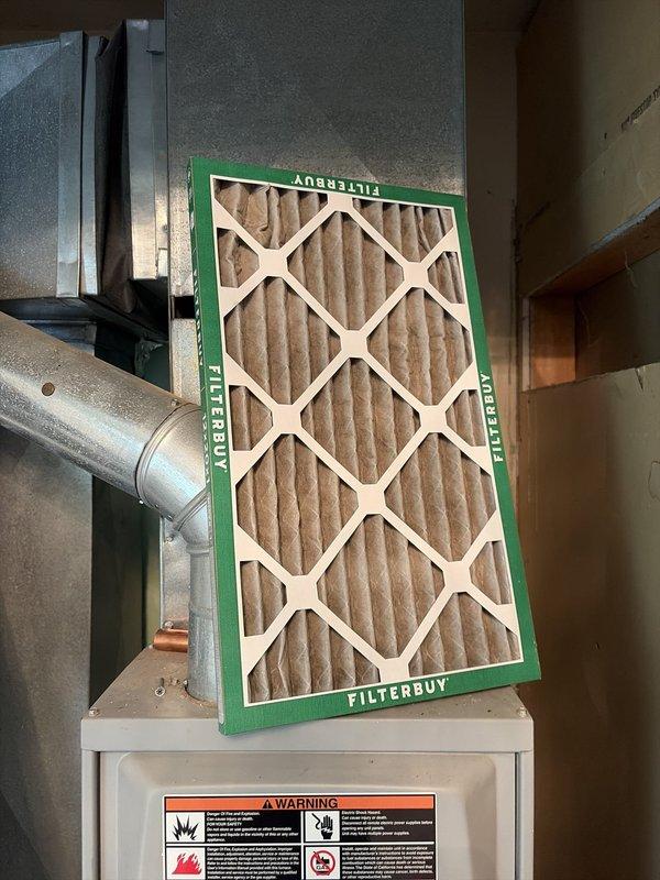 Performed HVAC tune-up service on residential air conditioning system. Inspected and replaced air filter with new FILTERBUY pleated filter at indoor air handler unit. Conducted electrical diagnostics at outdoor condenser unit using clamp meter, verifying voltage and amperage readings to ensure proper system operation and performance.