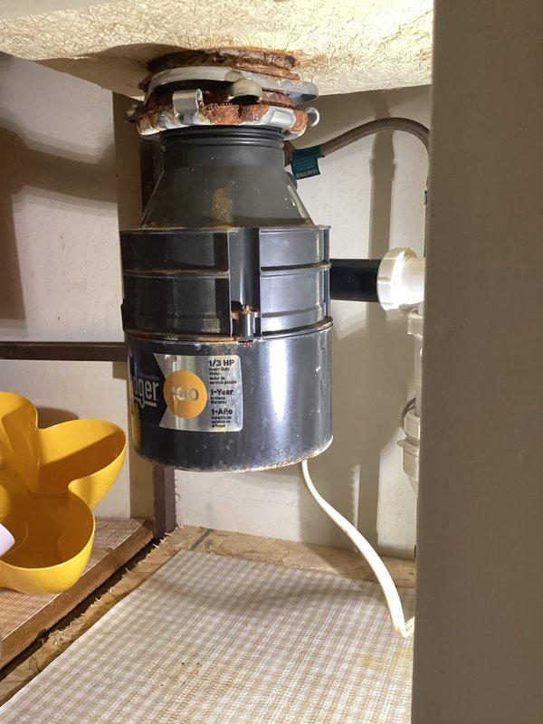 Responded to service call for garbage disposal repair and slow-draining bathroom fixture. Upon inspection, found heavily corroded copper drain piping and mounting hardware at disposal connection point showing significant rust and oxidation from prolonged moisture exposure. Repaired garbage disposal unit and addressed drainage issue in bathroom. Unit tested and confirmed operational upon completion.