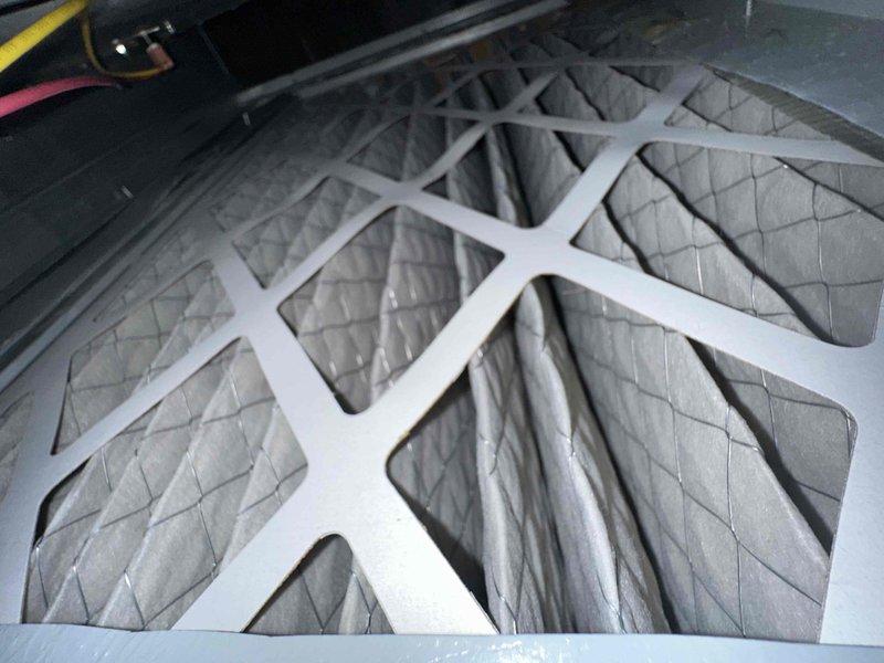 Completed scheduled preventive maintenance on residential cooling system. Inspected and serviced HVAC unit including filter examination in air handler compartment where multiple pleated filters were found properly installed in housing. Performed electrical diagnostics using clamp meter on outdoor condenser unit, verifying amperage draws and electrical connections. System operating within normal parameters with no deficiencies noted.
