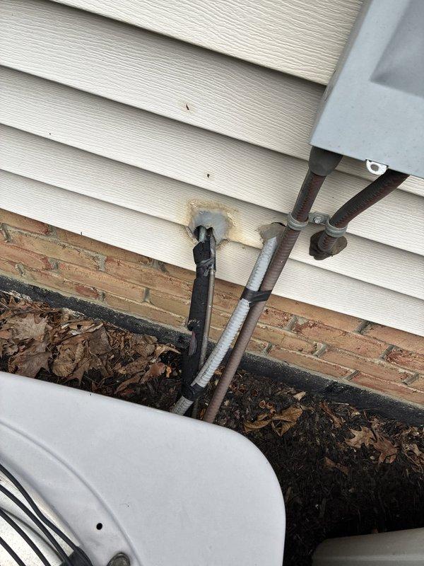 Completed estimate for full HVAC system replacement at residential property with easy access conditions. Assessed existing equipment including wall-mounted programmable thermostat, exterior refrigerant lines with deteriorating insulation, and condensing unit location showing aged pipe penetrations through vinyl siding with visible staining and compromised sealing. Documented current system configuration and provided recommendations for complete dual-system replacement to address equipment age, efficiency concerns, and exterior component degradation.
