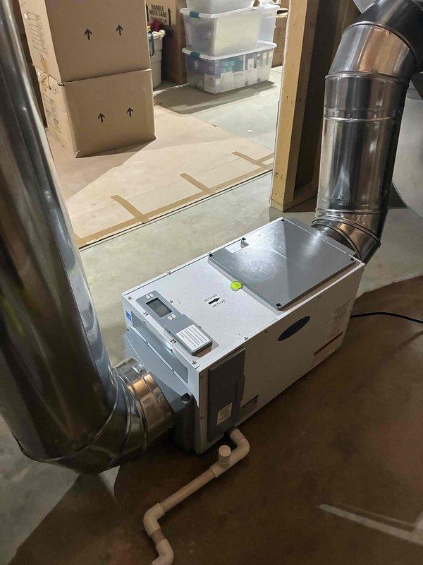 Returned to complete installation of whole home dehumidifier system integrated with existing Luxaire furnace and HVAC infrastructure. Connected dehumidifier unit to main supply plenum using properly sized metallic ductwork with appropriate elbow configurations, ensuring optimal airflow distribution throughout the system. Installed condensate drainage lines using PVC piping routed to floor drain, verified all electrical connections, tested unit operation for proper humidity control functionality, and confirmed system integration with existing heating and cooling equipment operates as designed.