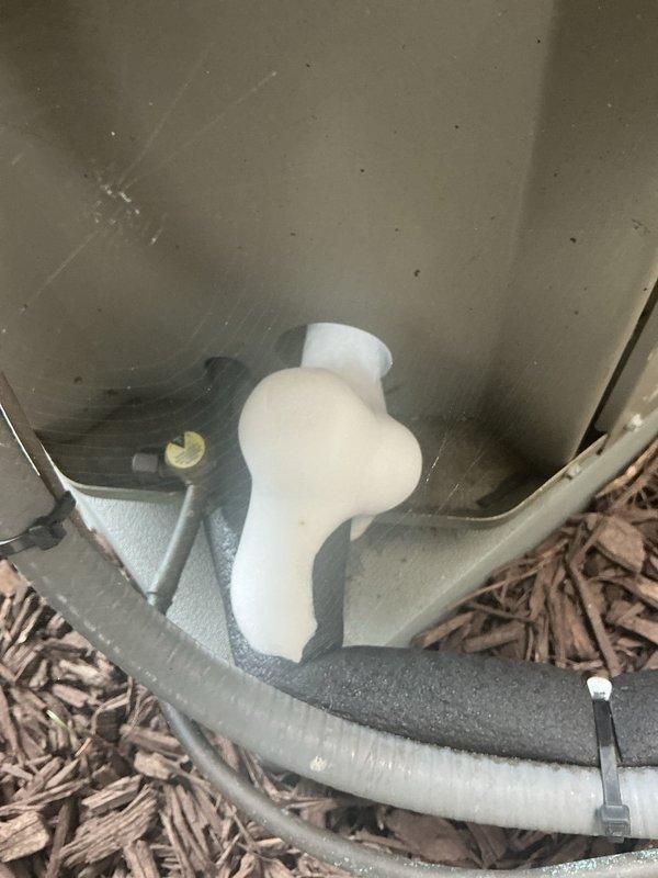 Responded to service call for air conditioning system with flashing green indicator light and frozen evaporator coil. Upon arrival, confirmed extensive frost and ice accumulation on evaporator coil fins and refrigerant lines. Inspected outdoor condensing unit and found refrigerant line connections and drainage components. Documented ice buildup on internal coil surfaces visible through heat exchanger fins, indicating restricted airflow or potential refrigerant flow issues causing coil to operate below freezing temperatures.