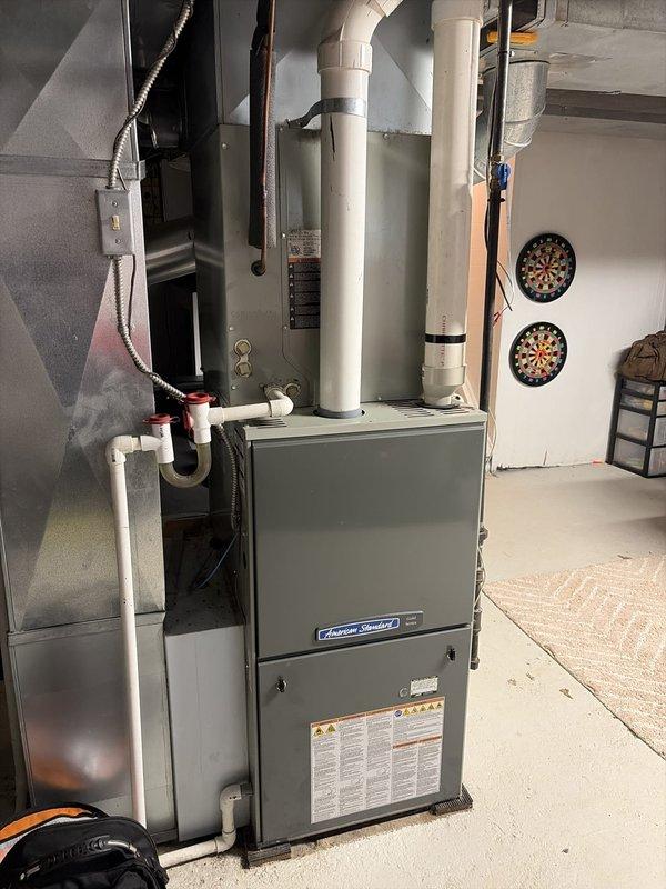 Completed scheduled preventative maintenance on residential cooling system as part of ongoing maintenance program. Performed comprehensive inspection of HVAC equipment located in basement utility area, including furnace unit and associated ductwork. Verified proper operation of air conditioning system, checked refrigerant levels, and inspected condensate drain lines with red-capped fittings. Measured supply air temperature at 56.1°F, confirming adequate cooling performance. Inspected PVC ventilation piping, electrical connections, and overall system integrity. All components found operating within normal parameters with no immediate service needs identified.