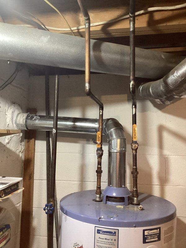 Conducted on-site evaluation for tankless water heater replacement. Assessed existing conventional storage tank water heater installation in basement utility area, including current plumbing connections, venting configuration, and available space for potential tankless unit installation. Documented existing setup showing water supply lines, pressure relief valve piping, shut-off valves, and gas or electrical connections to determine conversion requirements and provide accurate estimate for tankless water heater system upgrade.
