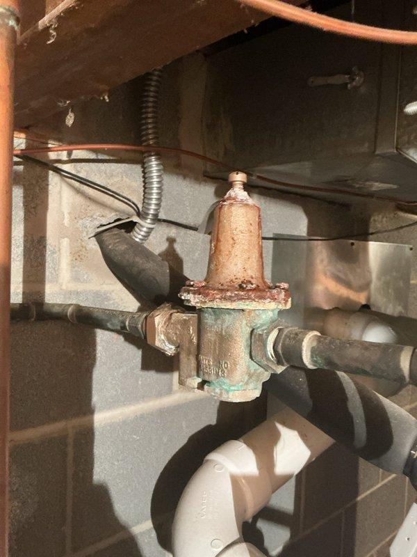 Performed routine maintenance on tanked water heater system, including complete flush to remove sediment buildup and ensure optimal performance. Inspected all associated plumbing connections, pressure relief valve, and supply lines, noting existing oxidation on brass fittings and pressure regulator valve consistent with normal aging of components; all connections remain secure and functional with no active leaks detected.