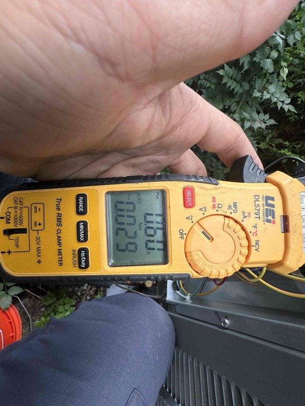 Completed routine HVAC cooling maintenance on air conditioning system. Performed system diagnostics including refrigerant pressure testing using manifold gauges, confirming pressures within normal operating range in the green zone for R-410A refrigerant. Measured electrical parameters with digital clamp meter, recording amperage draw of 22.2A and voltage reading of 11.01V to verify proper system operation and component performance.