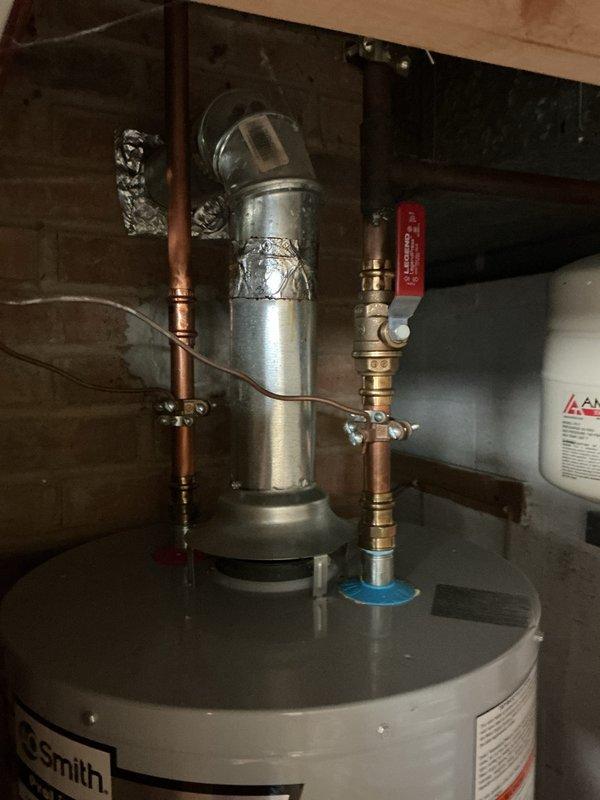 Completed comprehensive whole home plumbing inspection during afternoon visit. Thoroughly examined and documented water heater installation including A.O. Smith unit with expansion tank, copper supply lines, brass fittings, shut-off valves, and pressure regulation components. Inspected toilet flush valve mechanism and internal tank components to verify proper operation and functionality.