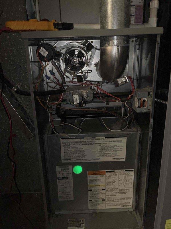 Completed scheduled preventive maintenance on residential cooling system. Performed comprehensive inspection of furnace and air handler unit, including examination of blower motor assembly, electrical connections, and control boards. Verified all wire terminations were secure at terminal blocks, confirmed proper grounding connections, and ensured all electrical components were functioning within normal parameters. System operational with green indicator light confirming normal status.