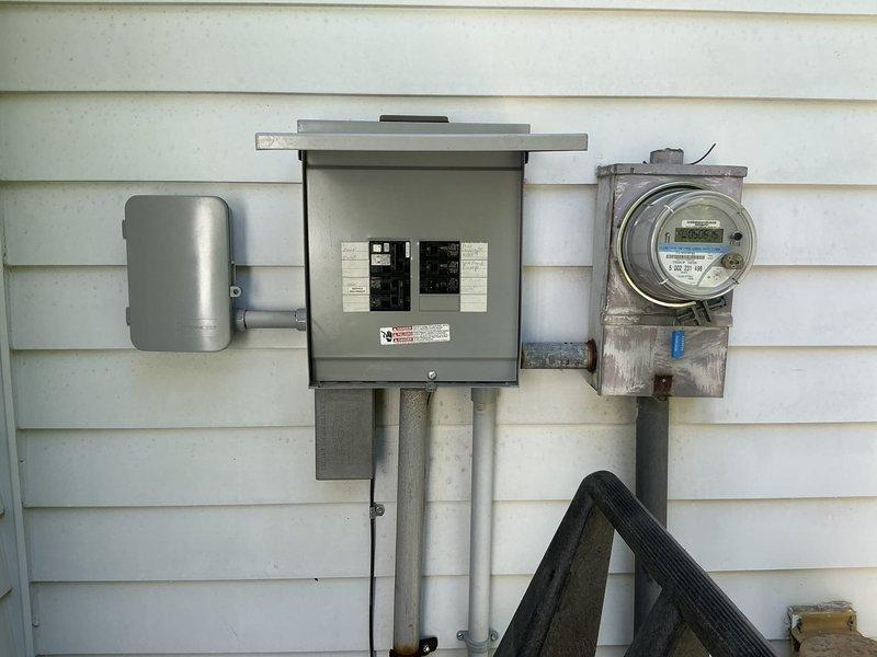 Conducted comprehensive site assessment for standby generator installation at residential property. Evaluated existing electrical service infrastructure including main distribution panel, utility meter assembly, and disconnect equipment mounted on exterior wall. Documented current electrical configuration with multiple conduits and service entrance components to determine generator integration requirements.

Inspected interior subpanel installation in basement utility area, noting existing circuit layout and available capacity for generator connection. Assessed grounding system, service feed routing, and panel configuration to establish proper automatic transfer switch placement and load management strategy for emergency backup power system.