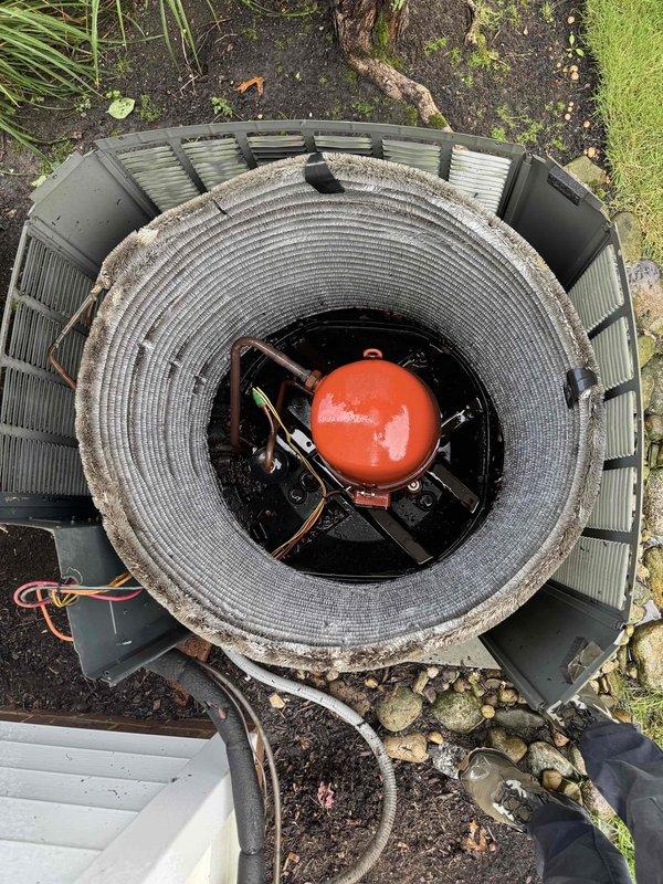 Completed preventive maintenance on aging outdoor cooling system. Inspected cylindrical condenser coil assembly, verified refrigerant line connections, and confirmed proper electrical circuit breaker operation at main panel. Unit operational with no immediate repairs required.