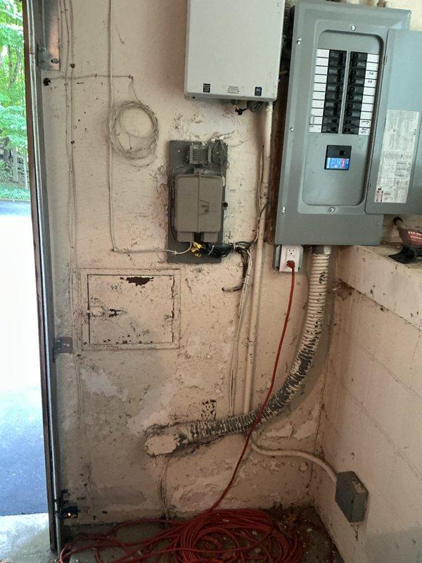 Conducted comprehensive electrical assessment for BMW i5 EV charger installation at residential garage location. Evaluated existing electrical infrastructure including main service panel with dual-row circuit breaker configuration, meter disconnect box, and junction boxes to determine capacity and compatibility for Level 2 charging station requirements. Documented current electrical system condition, identified appropriate circuit routing from panel to proposed charging location, and assessed conduit pathways for safe installation while noting existing flexible metallic conduit and wiring configurations that may impact installation approach.