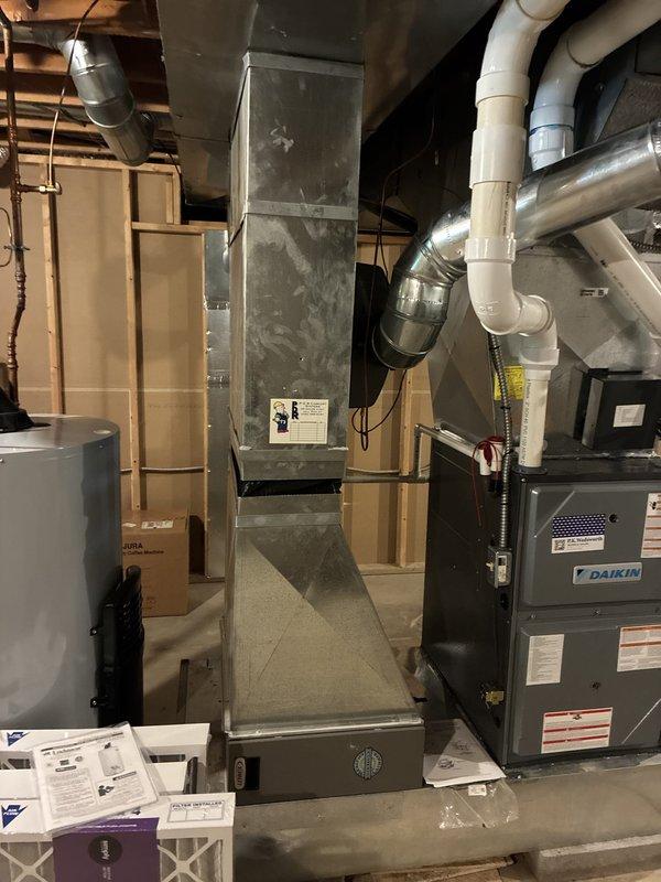 Conducted comprehensive system evaluation for residential HVAC replacement estimate due to inadequate airflow on second floor and partial airflow issues on main level. Assessed existing Daikin heat pump outdoor unit and indoor air handler system installed by previous contractor approximately two years ago. Performed visual inspection of outdoor condenser unit positioned on concrete pad with PVC supports, noting equipment specifications and current operational configuration. Evaluated basement-installed furnace and ductwork assembly, including vertical supply plenum, distribution system, and air handling components. Documented system layout including PVC condensate drainage, venting configuration, and filter accessibility. Analyzed heating and cooling load requirements relative to home square footage and current equipment capacity to determine proper system sizing. Photographed existing equipment installation, ductwork configuration, and mechanical room setup for replacement proposal do
