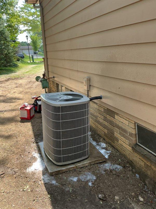 Relocated residential condenser unit to new position on concrete pad against exterior wall. Evacuated refrigerant system using manifold gauge set, disconnected electrical and refrigerant lines, repositioned unit, and reconnected all components. Recharged system to manufacturer specifications and verified proper operation of compressor and fan assembly.