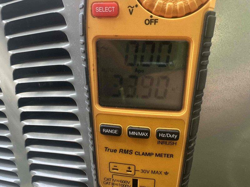 Completed afternoon cooling system tune-up for non-member residential unit. Performed standard maintenance inspection including electrical measurements using clamp meter at outdoor condensing unit, verified proper amperage draw showing 83.0 amps on display. Inspected exterior disconnect box and electrical connections at unit mounted on building foundation, noting weatherproof components in serviceable condition.