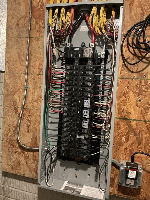 Installed dedicated electrical circuit from main service panel to garage, running new wiring through wall cavities and installing outlet box at designated location. Connected new circuit breaker in panel and verified proper grounding and electrical continuity throughout installation.