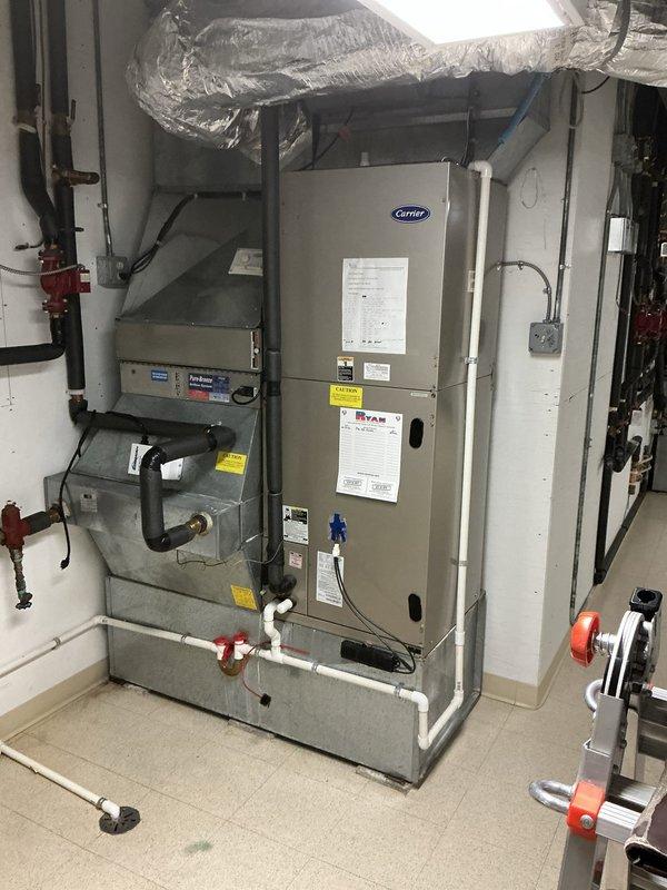 Conducted estimate for air handler and air conditioning replacement on unit #1. Evaluated existing Payne outdoor condenser positioned against brick wall exterior and Carrier air handler system in mechanical room with associated ductwork and piping connections. Documented equipment conditions and installation accessibility for replacement proposal.