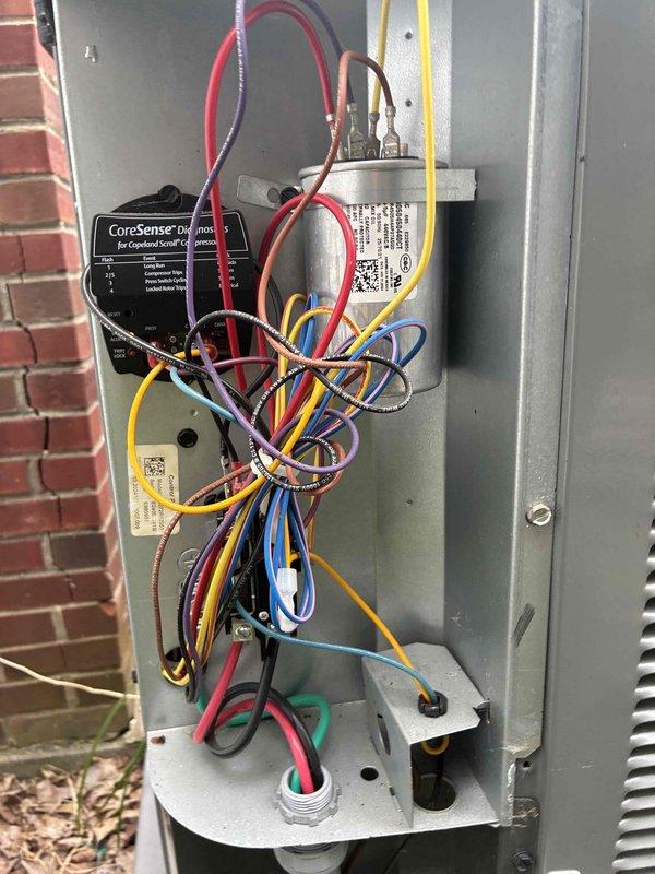 Completed scheduled cooling maintenance on residential air conditioning system. Performed electrical diagnostics using digital multimeter to verify proper voltage and amperage readings at the outdoor condensing unit. Inspected and documented control panel components including CoreSense monitoring device, transformer connections, and low-voltage wiring harness to ensure all electrical connections were secure and functioning within manufacturer specifications.